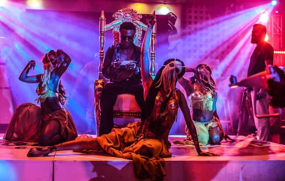Throne scene with performers in gold and jewelled costumes